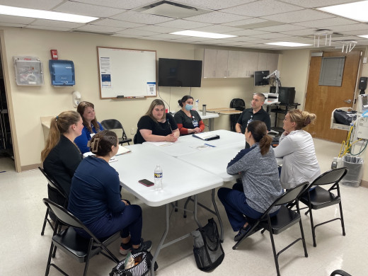  Debriefing after the first Sims scenario.  Pictured: Brittany Myers PACU RN, Rachel Altizer Sims Facilitator RN, Sarah Stover Sims HR Clinical Educator. Rachel Van Noord PACU RN, Emily Norman PACU RN, Shannon DeCourcey PACU RN, Jessica Shrewsbury PACU RN CTL, Dr. Michael Saccocci 