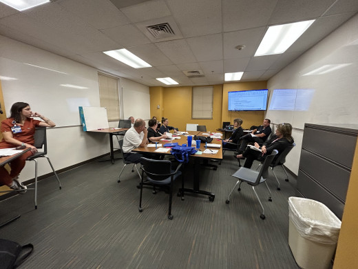 Teams holding a discussion about their response plan in a scenario that focuses on evacuation and maintaining services at an alternate location. 