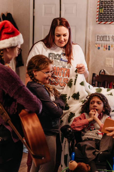 Hospice Music Therapist Jessie Palmer and Pediatric Hospice Nurse Krysta Smoot visit with a pediatric hospice patient and his sibling