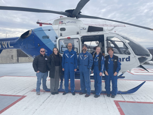 team posed outside of the helicopter before takeoff