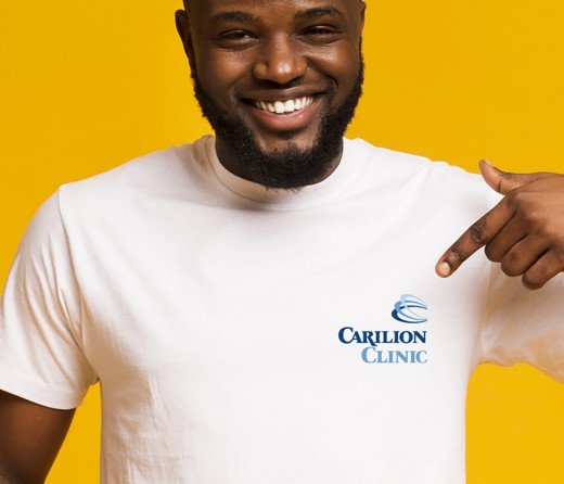 man wearing Carilion Clinic t-shirt on yellow background