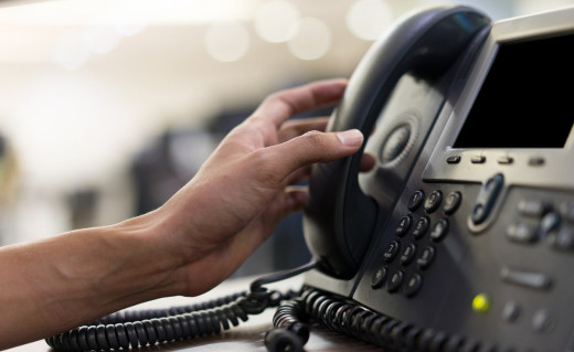 stock image of hand reaching to answer office phone