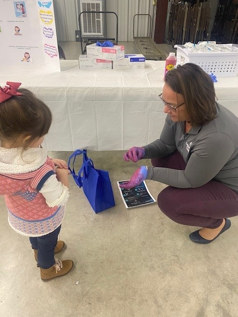 Melanie desmonstrating Hand Hygiene to a young learner 