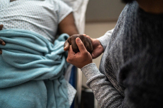 stock image of two people holding hands in hospital