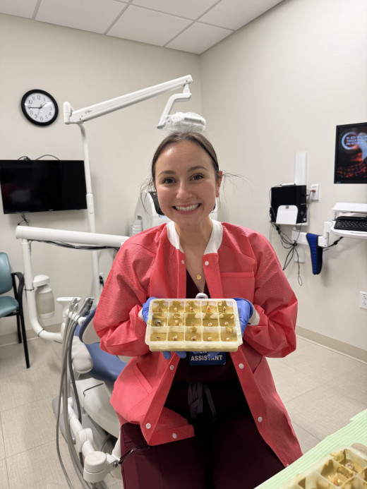 Bailey holding extracted teeth, to present to medical students at VTCSOM 