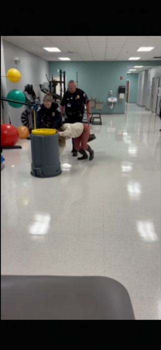 Pushing the raccoon out of the building with a trashcan.