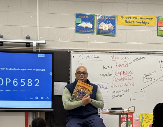 Supply Chain Manager Forrest Irving reads to 3rd grade class