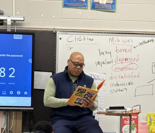 Supply Chain Manager Forrest Irving reads to 3rd grade class