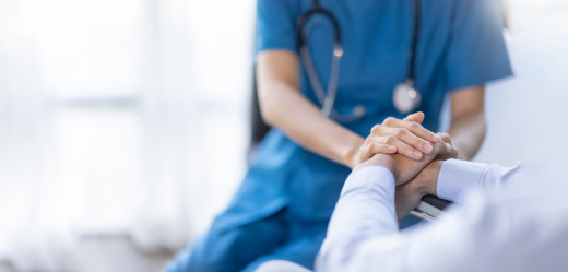 Healthcare worker holding hands with patient