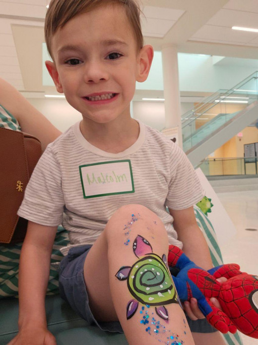NICU Graduate, Malcolm, showing off his shimmering Sea Turtle body art.
