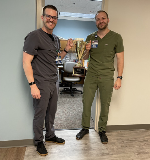 10 SICU Unit Director Robert Dingus and 8MICU Unit Director Carl Beggarly holding the ICU Strong Trophy