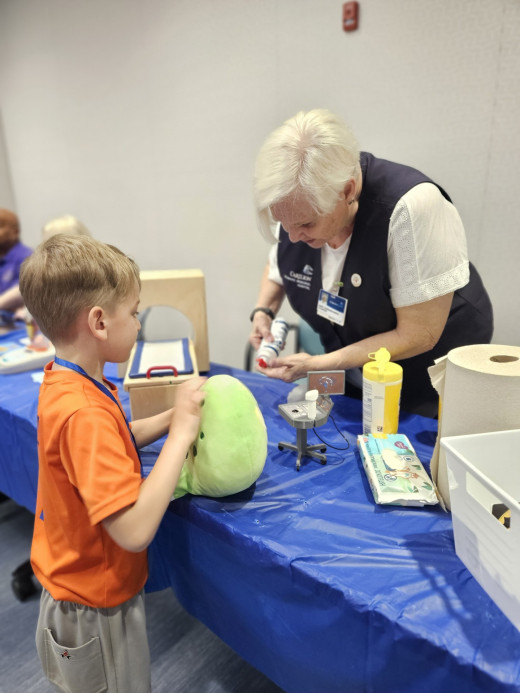A boy helping his stuffed animal get scans at our radiology station. 