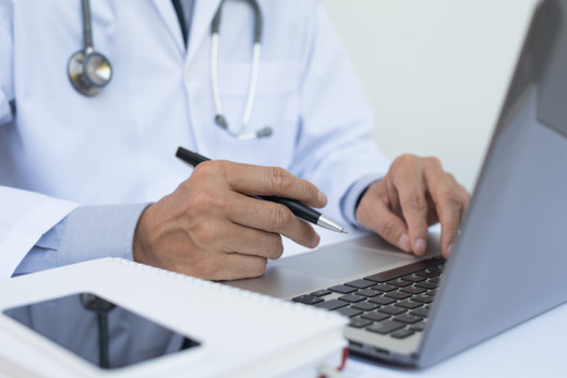 doctor typing on computer