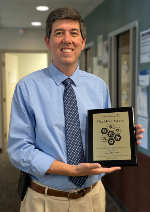 Dr. Thompson holding the Hive award plaque