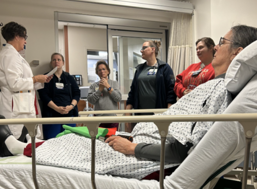 ED staff listen to patient case scenario.