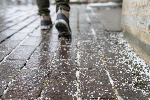 boots on an icy brick sidewalk