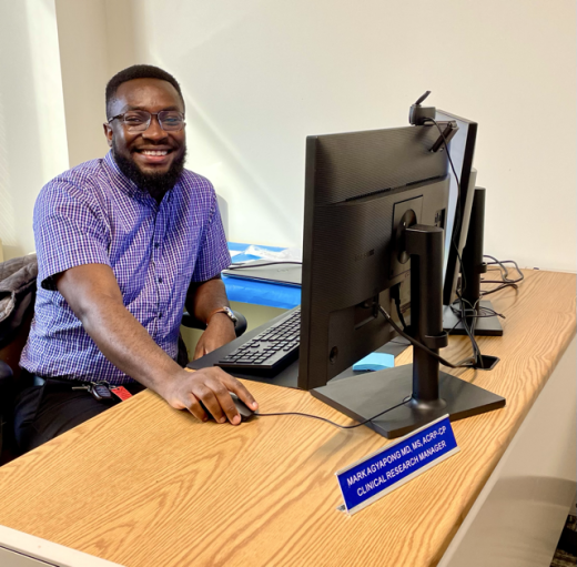 Dr Mark Agayapong sitting at computer 