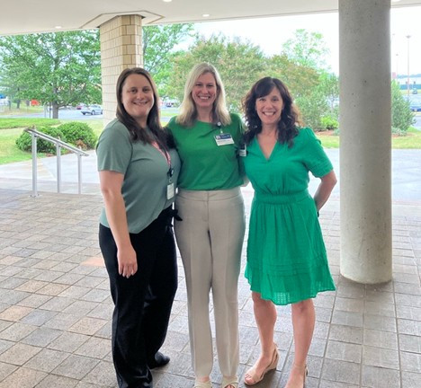 TSG team members Rena Hughes (from left), Laura Episcopo, and Karen Dillon wear green to support Mental Health Month in May. 