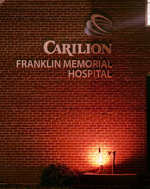 The CFMH logo on the hospital building, with red lights in honor of Nurses Week.