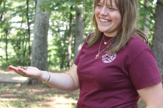 A young lady releasing a butterfly in her hand to honor her sister. 