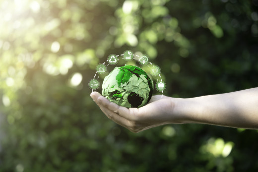 hand holding a green earth made of crumpled paper
